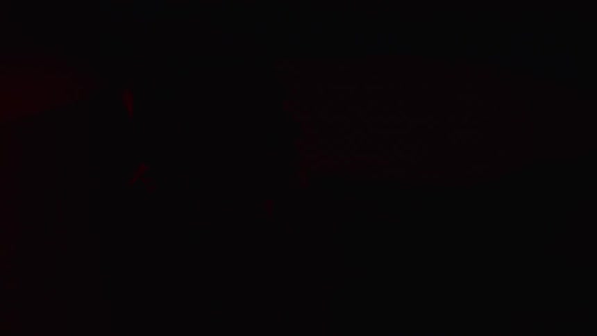 Red lights flashing on the face of a man inside a vehicle