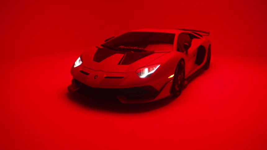 A lamborghini parked in a room lit with red light