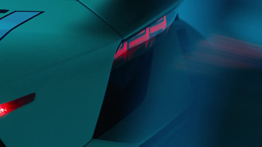 A blue light flashes on a luxury car in the dark