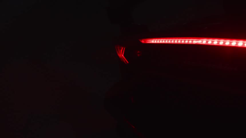 View of the rear bumper tail lights of a sports car in a garage