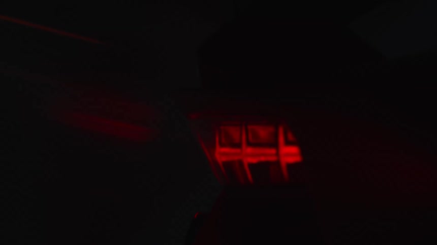 The rear of a lamborghini aventador illuminated by a saturated blue light