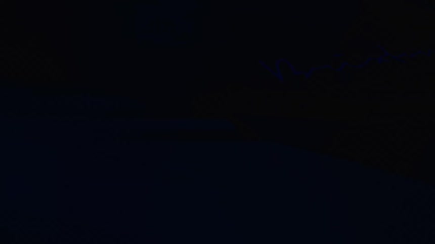 Silhouette of a person next to the lit headlight of a vehicle