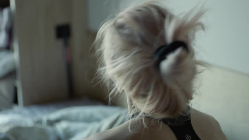 A woman is waking up in bed