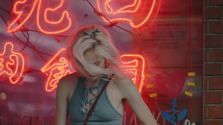 A woman is standing in front of a lit sign bobbing around