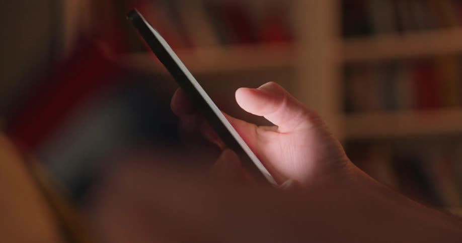 Thumb scrolling though social media holding cell phone with one hand