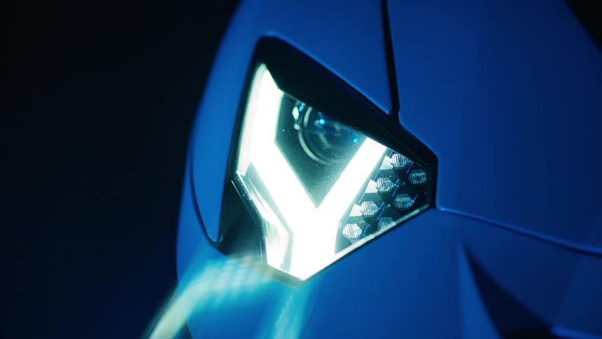 Close up of a blue sports car headlight at night