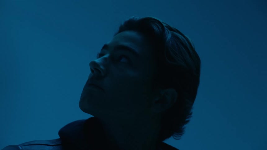 Young man looks up while flashing blue lighting illuminates the area