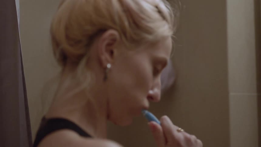 A woman is brushing her teeth