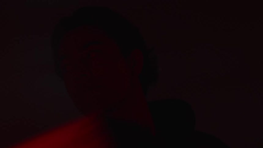 A man looks around the dark room