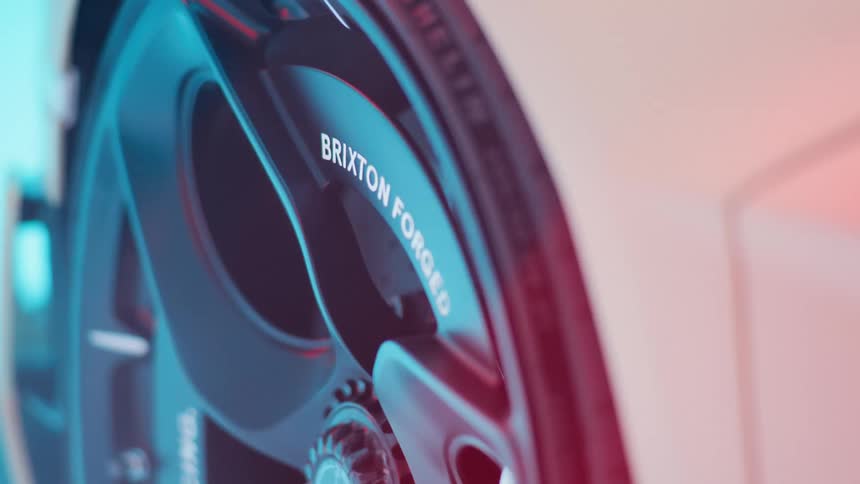 Close up of a modern sports car wheel illuminated by flashing blue and red lights