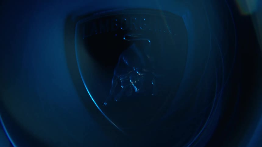Lights shine on the lamborghini emblem in the dark