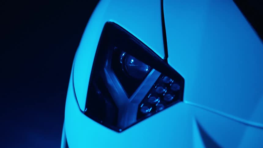 Close up of the headlights of a sports vehicle in a garage