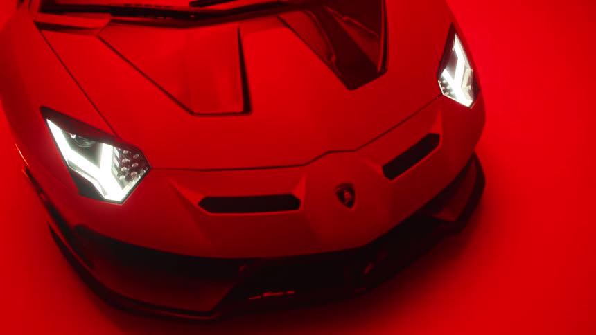 A red sports car turning on its headlights