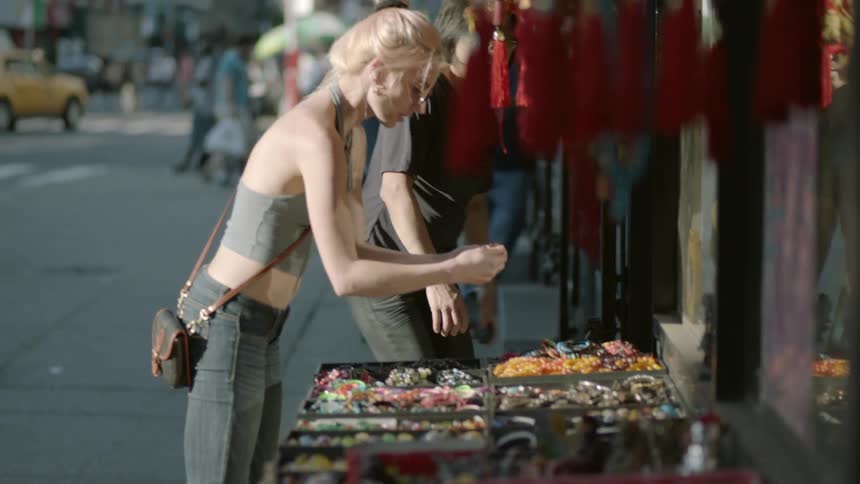 A blond woman shops at a street side shop