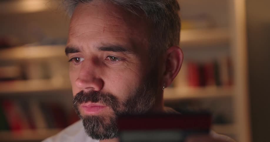 A man looking to the left and then looking at a credit card