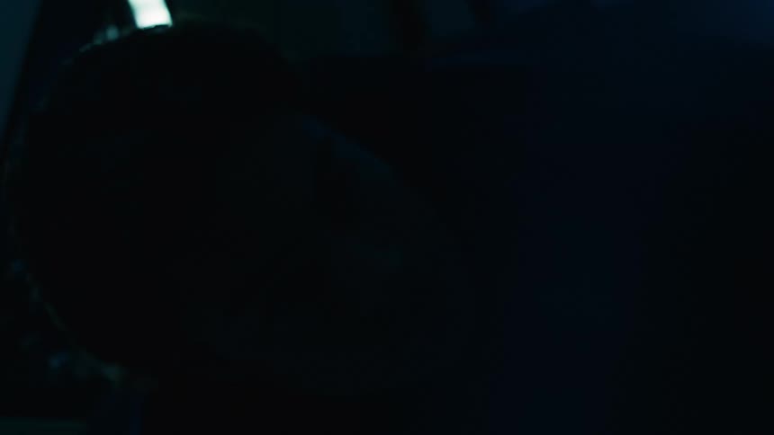 A man is sitting in the pitch darkness