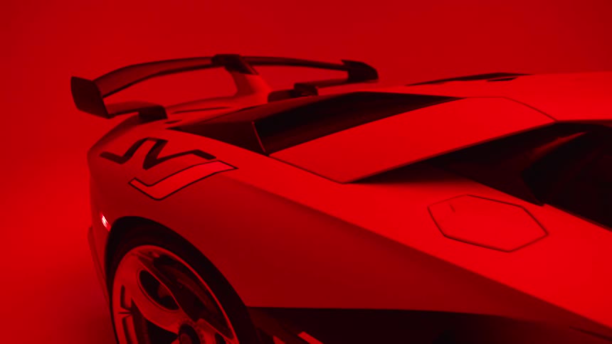 The rear of a white lamborghini aventador is illuminated by a saturated pulsating red light
