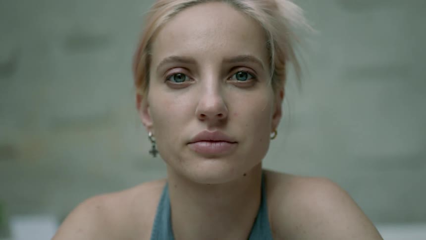A woman looks straight forward and blinks