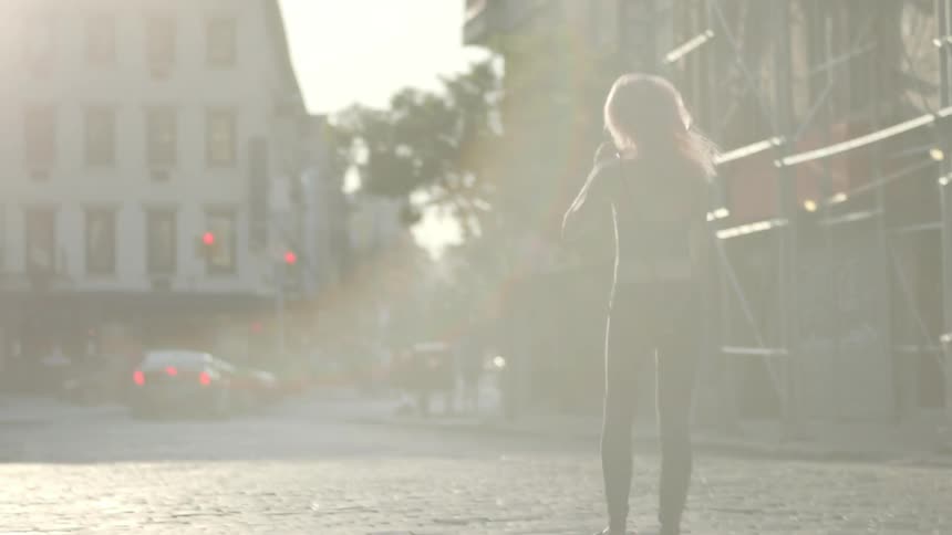 A person running and skipping down a brick road in a city