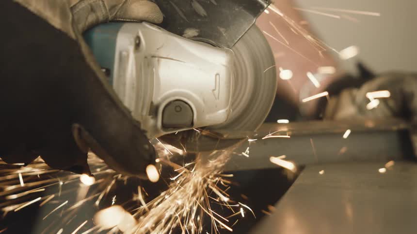 A person uses a saw to cut a piece of metal