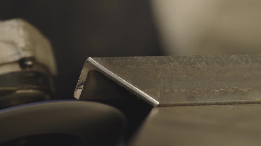 A rotating object scraping against a piece of metal and releasing several sparks