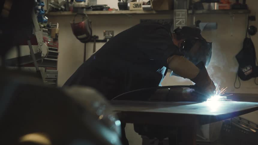 Man with protective mask making precise cut on an object