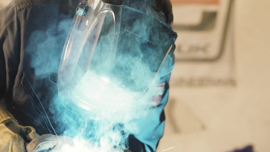 A man working welding metal pieces together