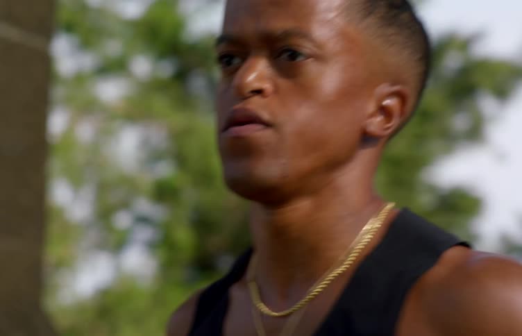 A young black man is running intensely for fitness captured in a closeup outdoor shot