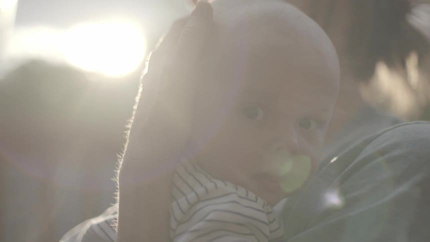 A woman holds a baby to her chest