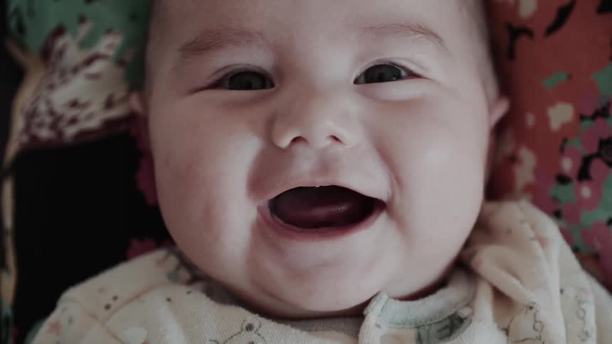 A smiling baby looks directly at the camera radiating joy and warmth