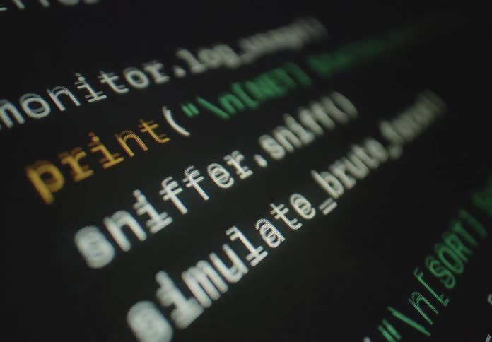 Lines of colorful computer programming code including functions like quicksort and print scroll across a dark screen with shifting focus