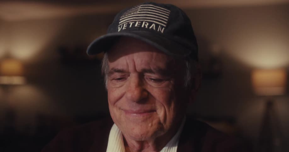 A man smiles and then types on his laptop