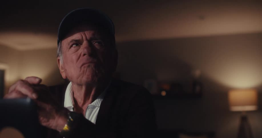 A man frowns as he thinks by the laptop