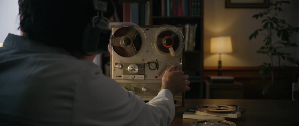 A man is listening to a tape recorder