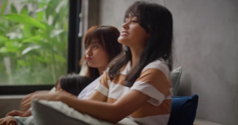 A family sits together on the couch