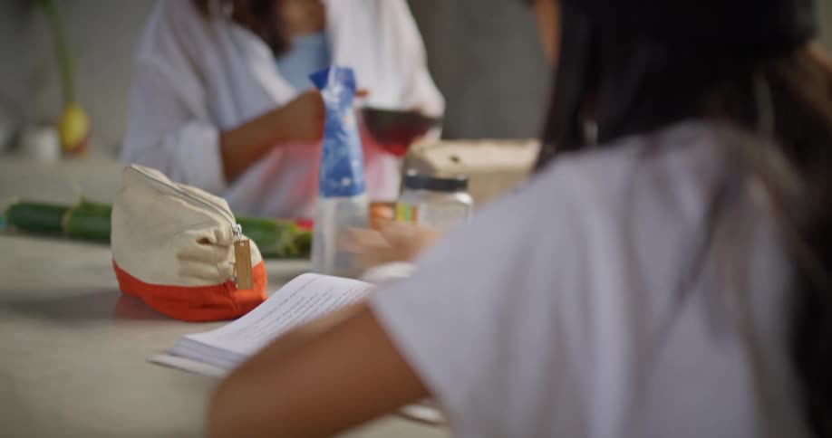 A mother and daughter chat warmly over food while studying at the kitchen counter
