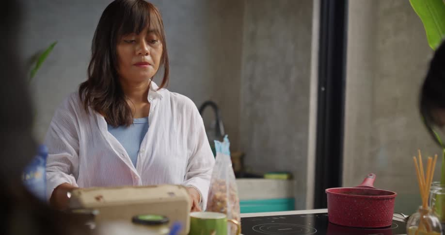 A mother talks as she cooks in the kitchen