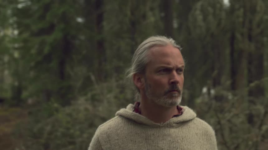 A man is hiking through the woods