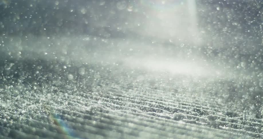 The snow is falling fast on a sunny day