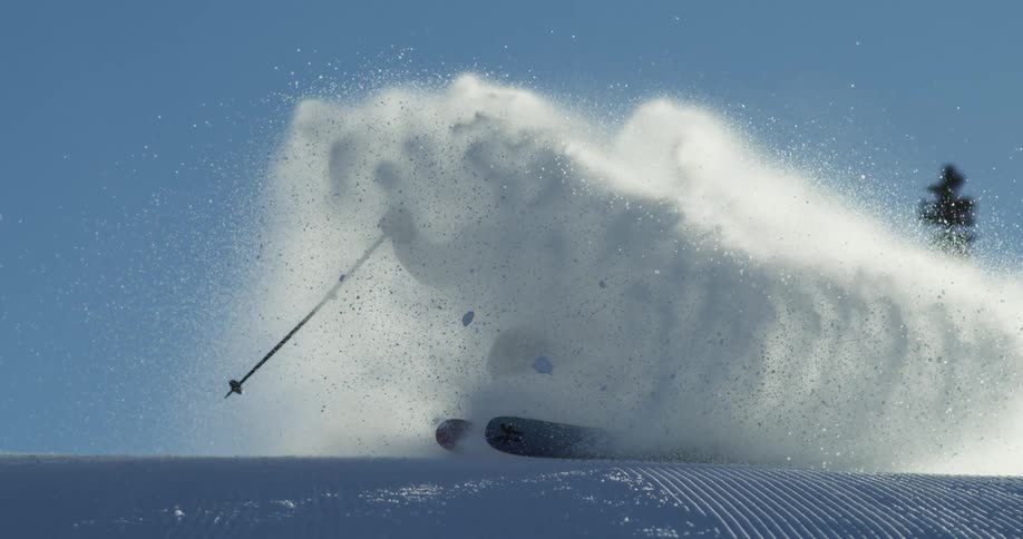 A person jumps over the hill while skiing in the snow