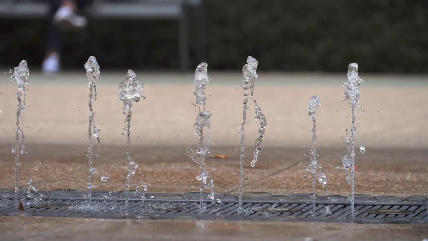 Water streams are dancing in a fountain during the day
