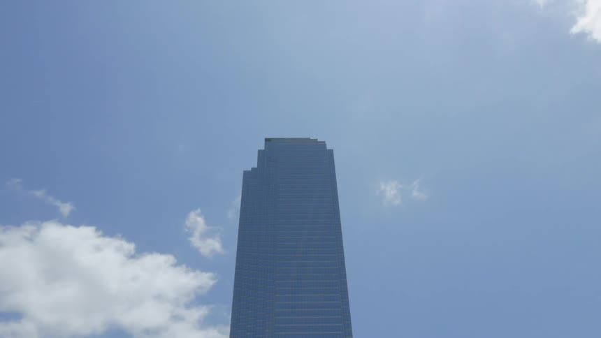 Clouds move fast over a skyscraper on a sunny day