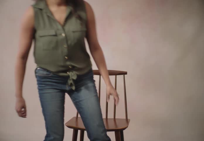 Woman smiling and sitting on a wooden chair