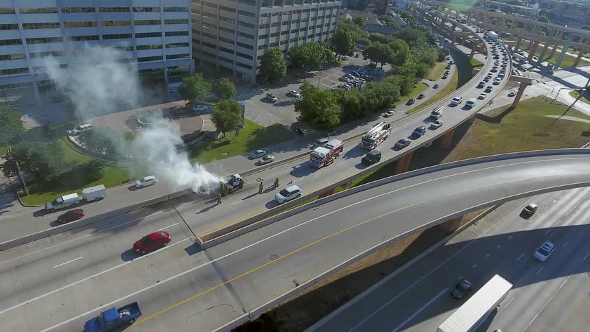 An overhead view of a road with an accident and a car smoking