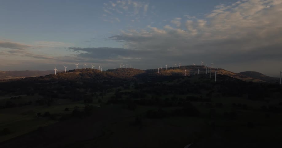 Windmills on hills at sunrise