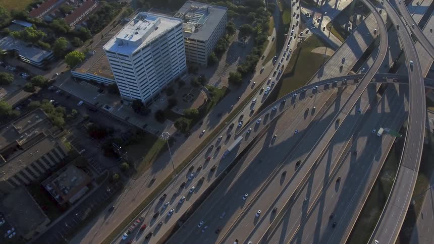 Cars drive on a highway system in a city