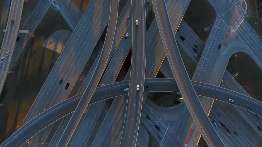 A row of intersecting roads have cars traveling in all directions below