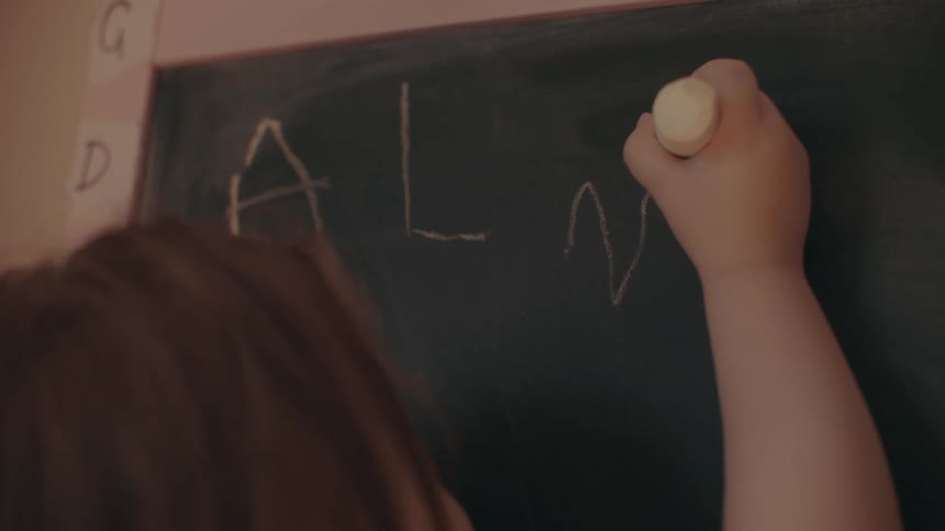 A student is writing on the chalkboard