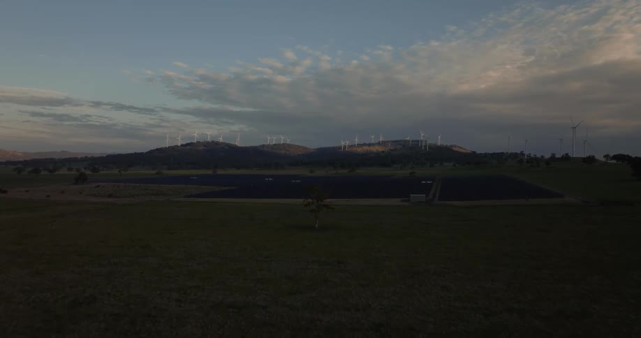 Aerial view of farmland near some hills at sunrise