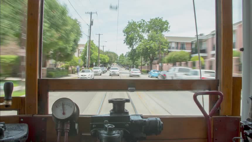 A trolley car travels down a city road